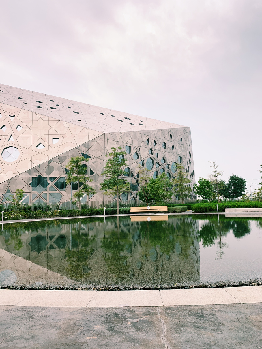 Modern building exterior near trees and pond